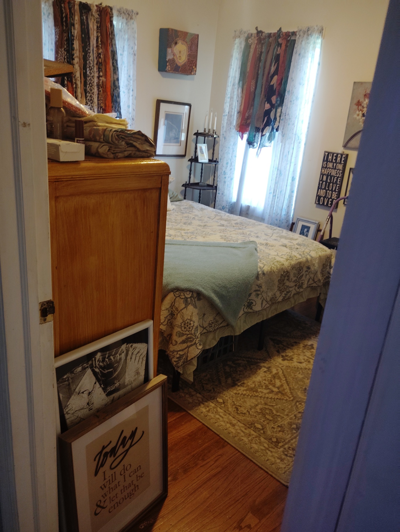 View into Weston's bedroom from the doorway at the Cat Nap Inn, showing the bed, rug, and framed art